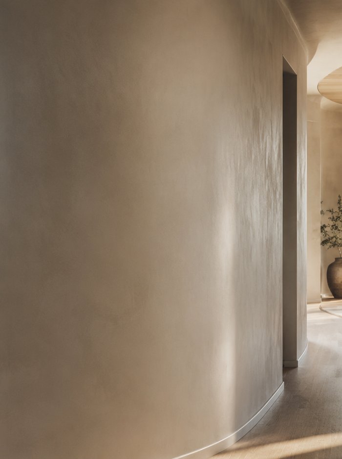A quiet, sunlit plaster wall and open doorway